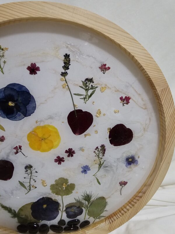 Round Wall art made of Pressed flowers and resin with rocks at the base. Blue Tones
