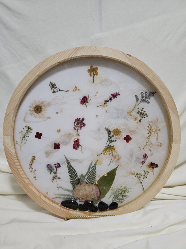 Round Wall art made of Pressed flowers and resin with rocks at the base. Pink Tones